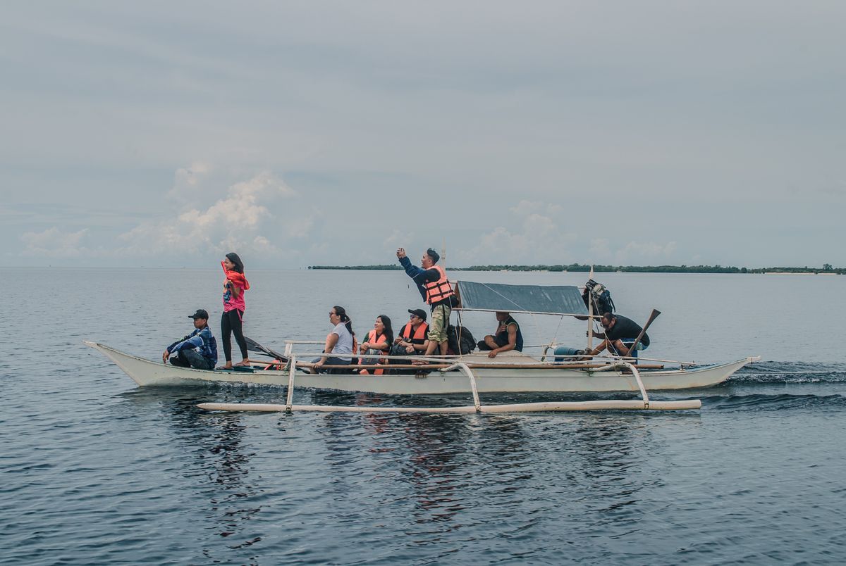 Travelers on an outrigger boat heading out to the islands